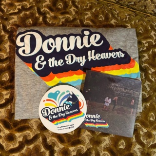 YOU COULD WIN…
::
A Donnie and the Dry Heavers t-shirt, CD, and sticker! 🤩
::
Courtesy of @donnieandthedryheavers 

Don’t miss this talented group of groovy dudes playing live on Saturday! 
::
When you turn in your completed passport you will be entered in our prize drawing where you could win THIS and some other pretty rad prizes. 🤩
::
For information on the 
🏆 4th Annual Tasty Buds Throwdown 🥊
see High Voltage’s social media.